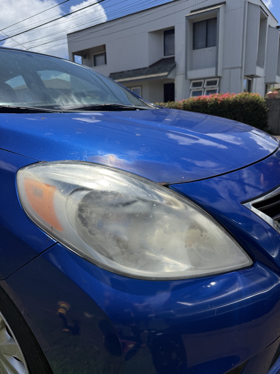 Cloudy blue Nissan headlight before restoration, angle one