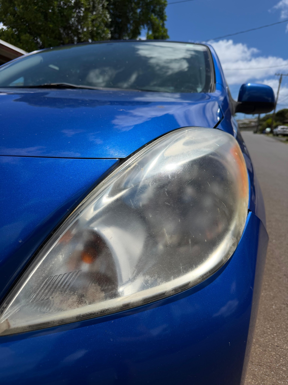 Cloudy blue Nissan headlight before restoration, angle two