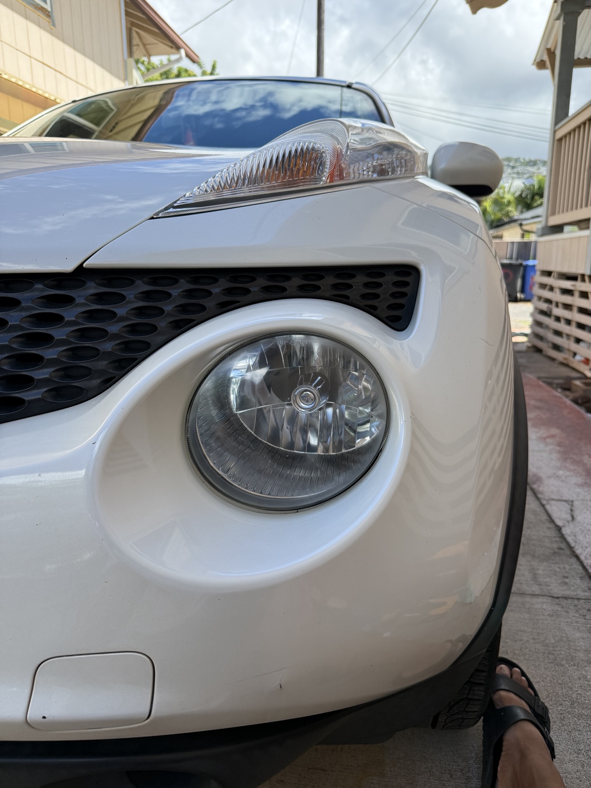 Clear round headlight on white Nissan after restoration